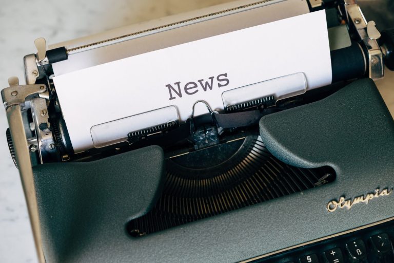Close-up of a vintage Olympia typewriter with paper reading 'news'. Perfect for classic journalism themes. — Die wichtigsten