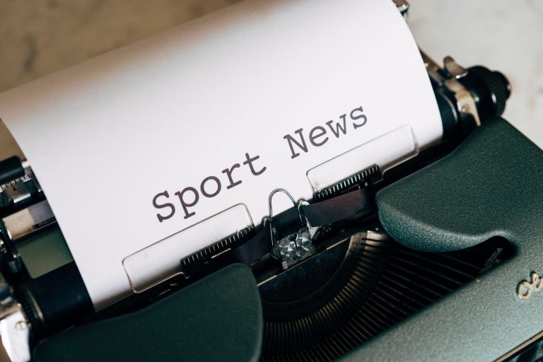 Close-up of a vintage typewriter with 'Sport News' typed on paper, evoking retro charm. — Was macht Fambet Casino so besonder